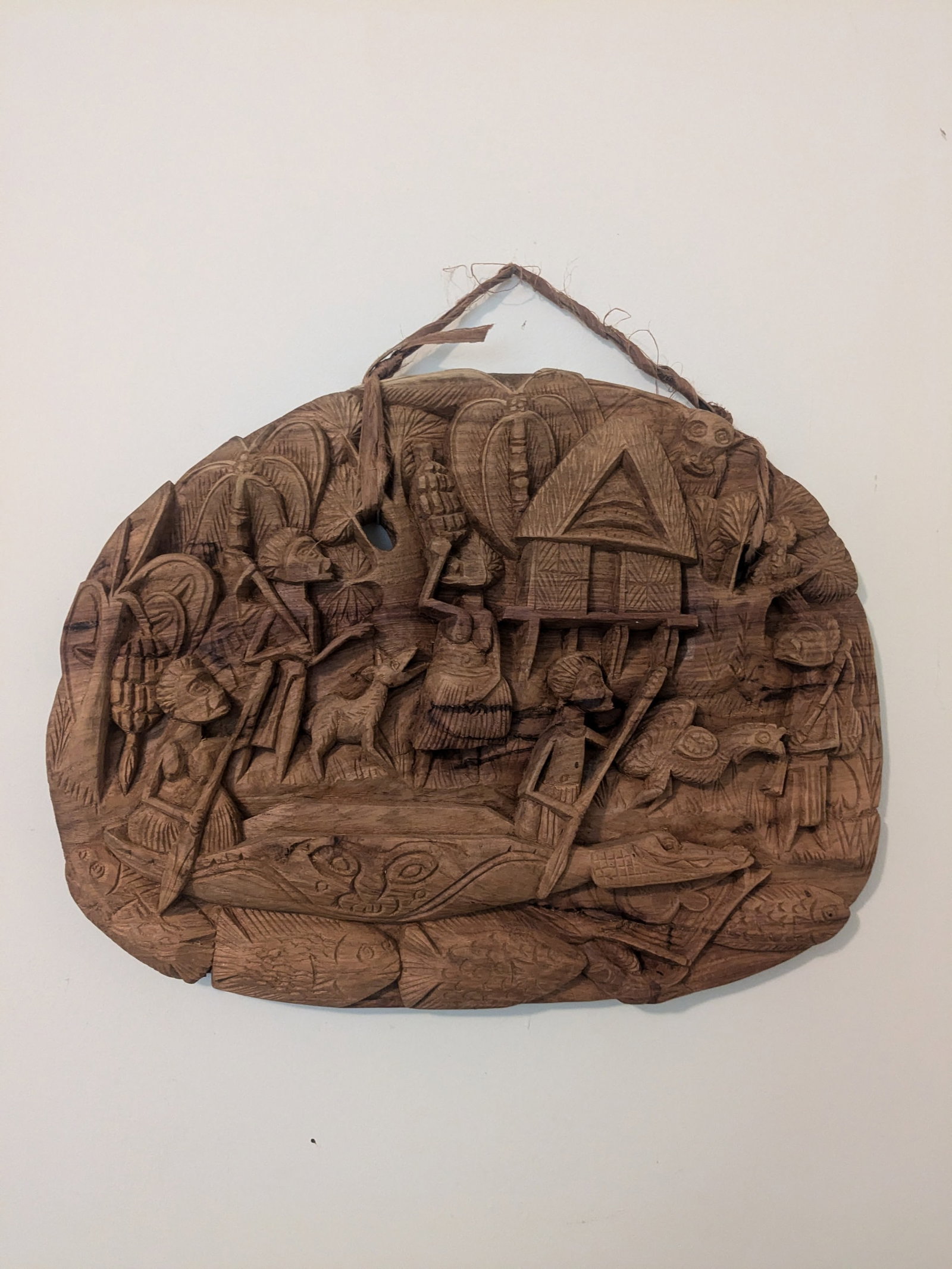 Story Board with Bush Rope Hanger: Title:Story Board with Bush Rope Hanger Description:Finely detailed, carved relief of village scene on the banks of the Sepik River, Papua New Guinea. This piece showing villagers working, Crocodile