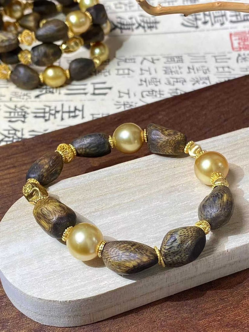 925 Sterling South Sea Golden Pearl Bracelet: Title: 925 Sterling South Sea Golden Pearl Bracelet Description: This bracelet perfectly combines the national style of agarwood with golden pearls, showcasing the elegance and warmth of the East. Eac