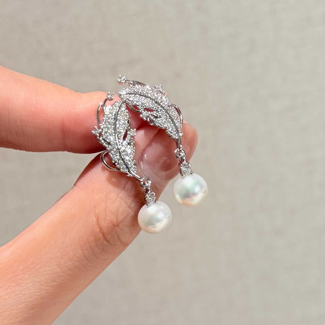 Natural Freshwater Pearl Earrings: Title: Natural Freshwater Pearl Earrings Description: These earrings feature natural freshwater pearls, showcasing the high-quality luster of the pearls. The fine craftsmanship creates a feather-like