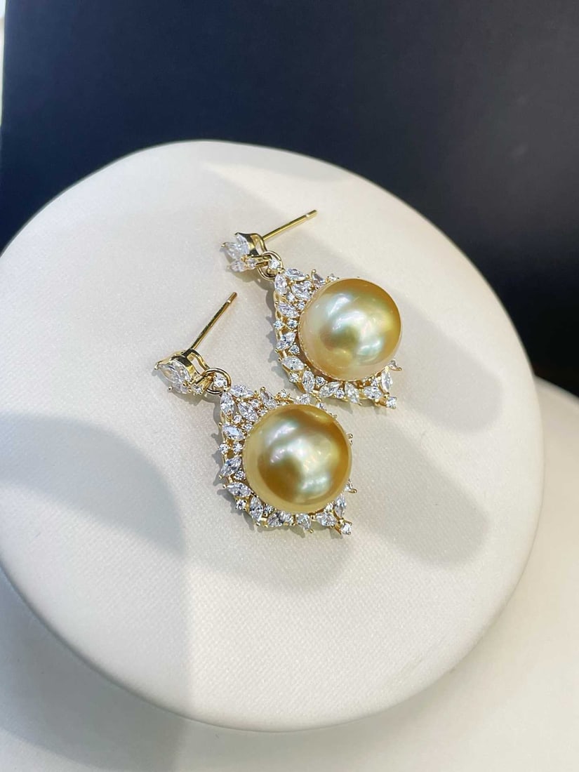 925 Silver Edison Pearl Earrings: Title: 925 Silver Edison Pearl Earrings Description: These earrings are inspired by dynamic flame designs, featuring 12mm near-round warm golden Edison pearls with a soft satin luster. Surrounded by d