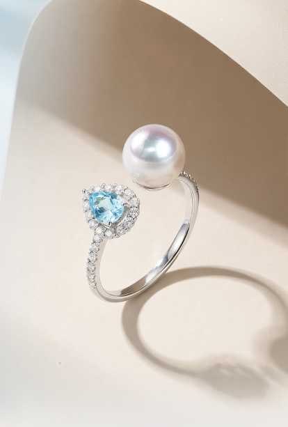 18K Gold Akoya Pearl Ring: Title: 18K Gold Akoya Pearl Ring Description: This ring features an 18K gold base, set with refreshing blue topaz and Akoya pearls, showcasing a blend of elegance and classic style. The aurora luster 
