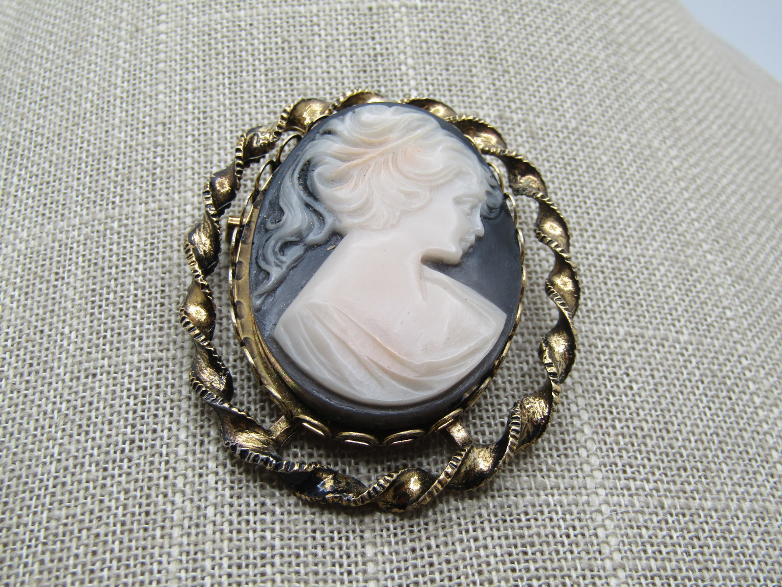 Vintage Cameo Brooch, Black & White , 1960's: Title: Vintage Cameo Brooch, Black & White , 1960's Description: Vintage Cameo Brooch, Black & White , 1960's. It is appx. 2" tall and nearly 1.75" wide. It has a twisted gold tone frame with open