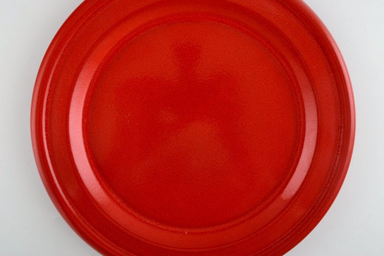 Emile Henry, France. Eight dinner plates in glazed stoneware. Beautiful glaze in shades of red. Mid - 4