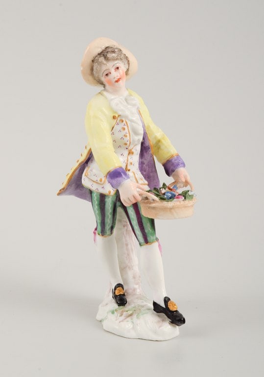 Presumably German porcelain figure, man with flower basket, 19th century.: Presumably German porcelain figure, man with flower basket, 19th century. Indistinctly signed. Hand painted. Marked on the back. In excellent condition. H 12.5 cm. D 4.5 cm. Reserve: $168.00