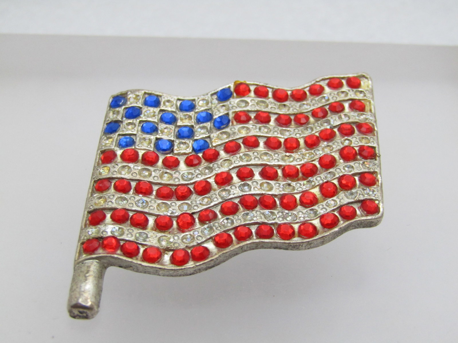 Vintage USA Rhiinestone Flag, 1.75", 1960's-1970's: Title: Vintage USA Rhiinestone Flag, 1.75", 1960's-1970's Description: Vintage USA Rhinestone Flag, 1.75", 1960's-1970's. Silver tone with blue rhinestones set as stars and red as the waving stripes. 