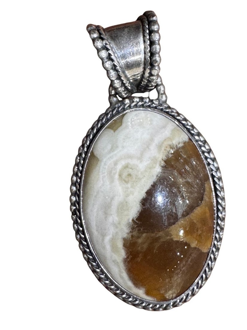 Native American Sterling Silver and Jasper Pendant by Ben Begaye: This exquisite Native American pendant features a cabochon-cut jasper stone, with swirling patterns of earthy brown and creamy white, set in a sterling silver bezel. The silverwork is meticulously