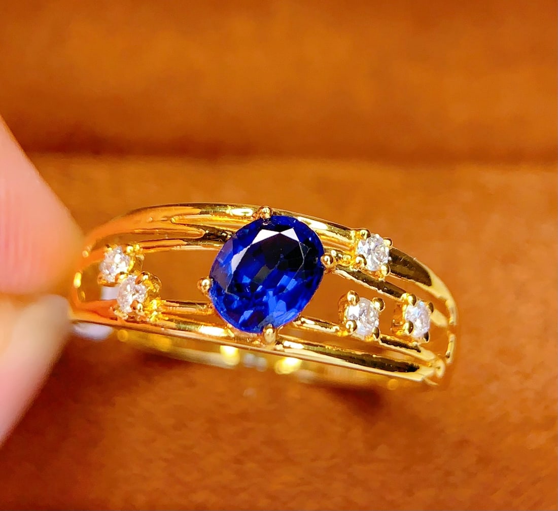 18K Gold Natural Sapphire Ring: Title: 18K Gold Natural Sapphire Ring Description: This ring is meticulously crafted in 18K gold, set with a natural sapphire that exudes a captivating brilliance. Five diamonds accentuate the piece, 
