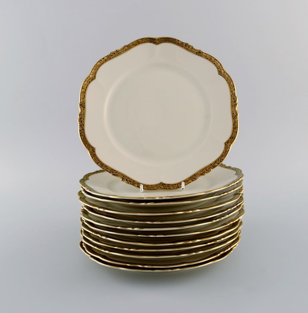 KPM, Berlin. Twelve Royal Ivory lunch plates in cream-colored porcelain with gold decoration. 1920s. - 2
