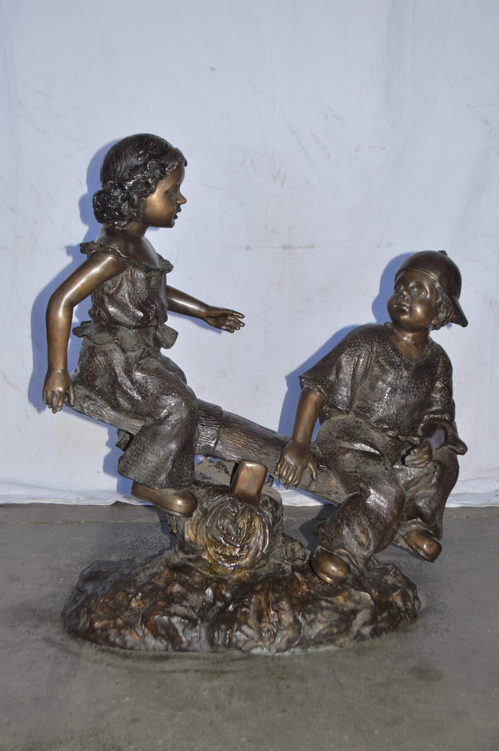 A Boy and a Girl Playing Seesaw Bronze Statue - Size: 17"L x 33"W x 36"H. - 4