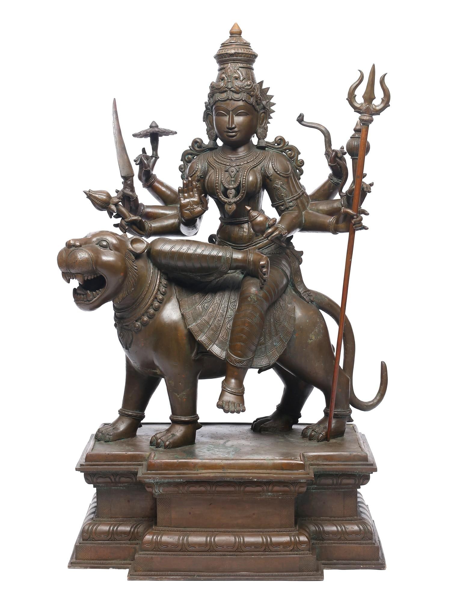 A Nearly Perfect Statue of Goddess Durga: Large Size Panchaloha Bronze Statue: Title: A Nearly Perfect Statue of Goddess Durga: Large Size Panchaloha Bronze Statue Description: This museum-quality bronze of Goddess Durga captures the perfect equilibrium of power and beauty, embo