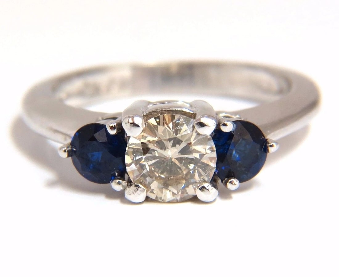 1.44CT NATURAL ROUND DIAMOND & SAPPHIRE THREE STONE CLASSIC 14KT**: Three Stone Fancy .72ct. Natural round diamond ring L-color Si-1 clarity 6.04mm diameter Very good Cut / Full cut Brilliant .72ct Side natural (2) sapphires Top Royal Blue & Clean Clarity. 14kt white