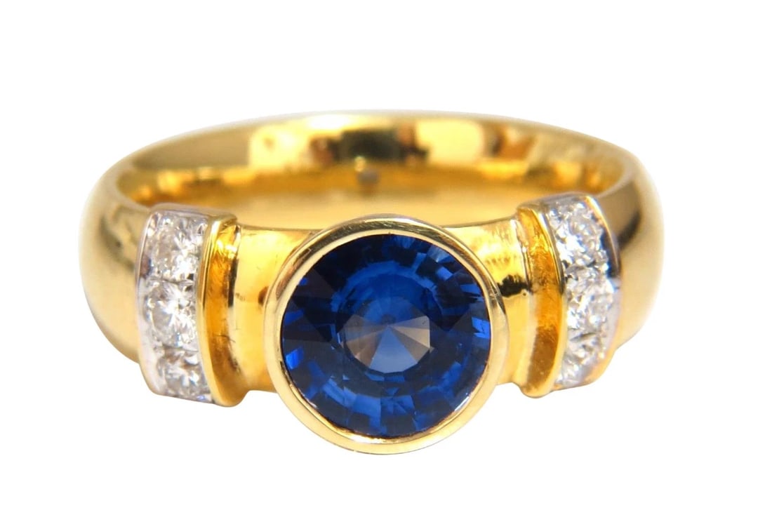 1.50ct natural vivid blue round sapphire diamonds ring 14kt Benchmark Comfort *v: Blue Sapphire / Simple Flush Bezel 1.20ct. Natural blue sapphire ring. Clean clarity. Round full cut 7mm Diameter Transparent, Vibrant vivid blue color .30ct. Side natural round diamonds: G-color,