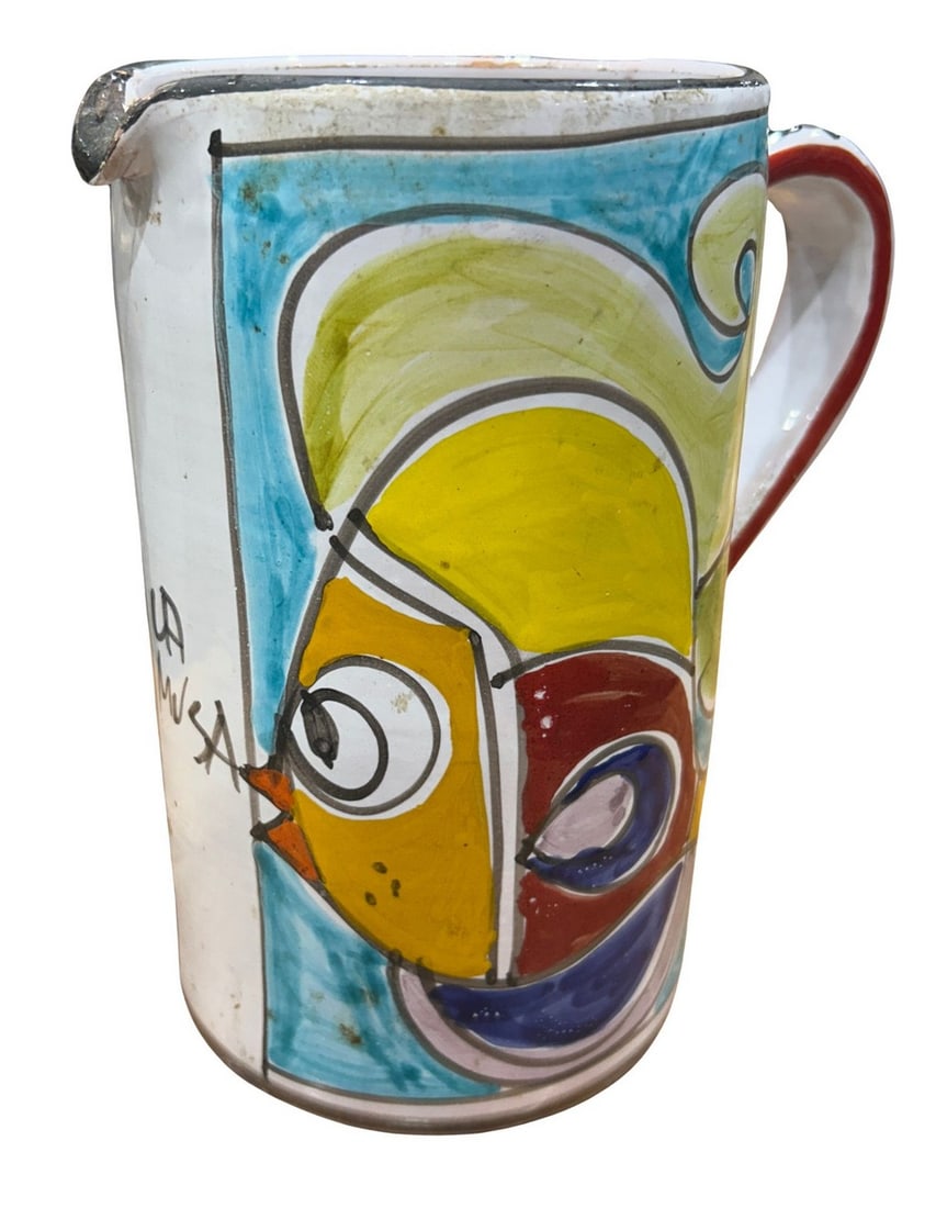 Hand-Painted Italian Maiolica-Style Ceramic Mug: This vibrant hand-painted ceramic mug features a lively maiolica-style decoration with abstract motifs in bold primary colors: yellow, red, blue, and black. The design evokes a playful character or bi