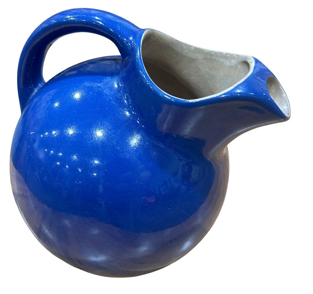 Mid-Century Modern Cobalt Blue Glazed Ceramic Pitcher: This mid-century modern ceramic pitcher features a vibrant cobalt blue glaze, giving it a striking and functional design. Its spherical body and angular spout suggest a minimalist aesthetic, indicativ