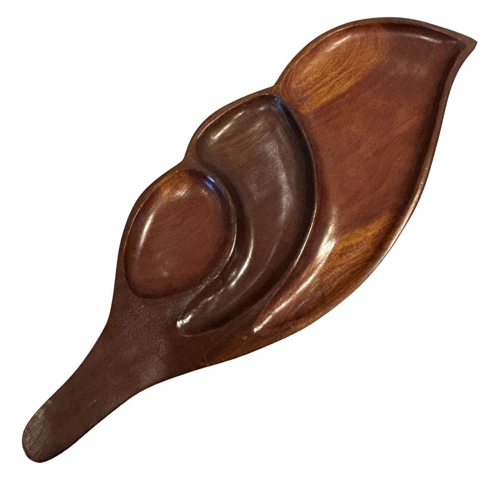 Mid-Century Modern Carved Wooden Leaf-Shaped Serving Tray: This mid-20th century serving tray is expertly carved from a single piece of rich, dark wood into an organic, leaf-like form. The tray features three distinct, organically shaped compartments, perfect