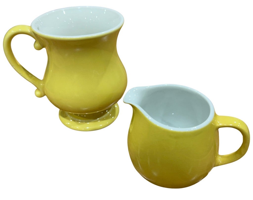 Pair of Mid-Century Modern Yellow Ceramic Creamers by Arabia and Ernest John: This lot features a pair of mid-century modern ceramic creamers. One creamer is by Arabia, made in Finland, and the other is by Ernest John, made in the U.S.A. Both creamers boast a vibrant yellow gla