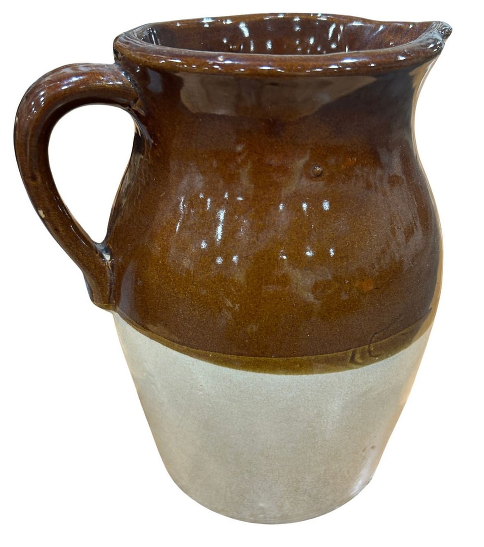 Vintage Two-Tone Glazed Pottery Jug: This vintage pottery jug features a distinctive two-tone glaze, with a rich brown on the upper portion and a contrasting natural light beige on the lower section. The jug has a classic form with a