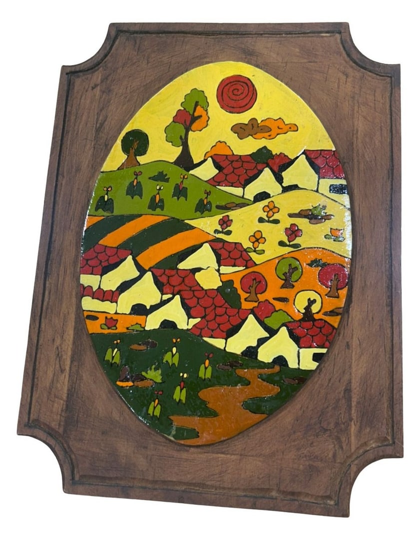 Colorful Folk Art Enamel on Wood Plaque, Mid-20th Century: This vibrant mid-20th century folk art plaque features an oval enamel scene depicting a lively village landscape with houses, trees, and figures, all rendered in a distinctive naive style. The colorfu