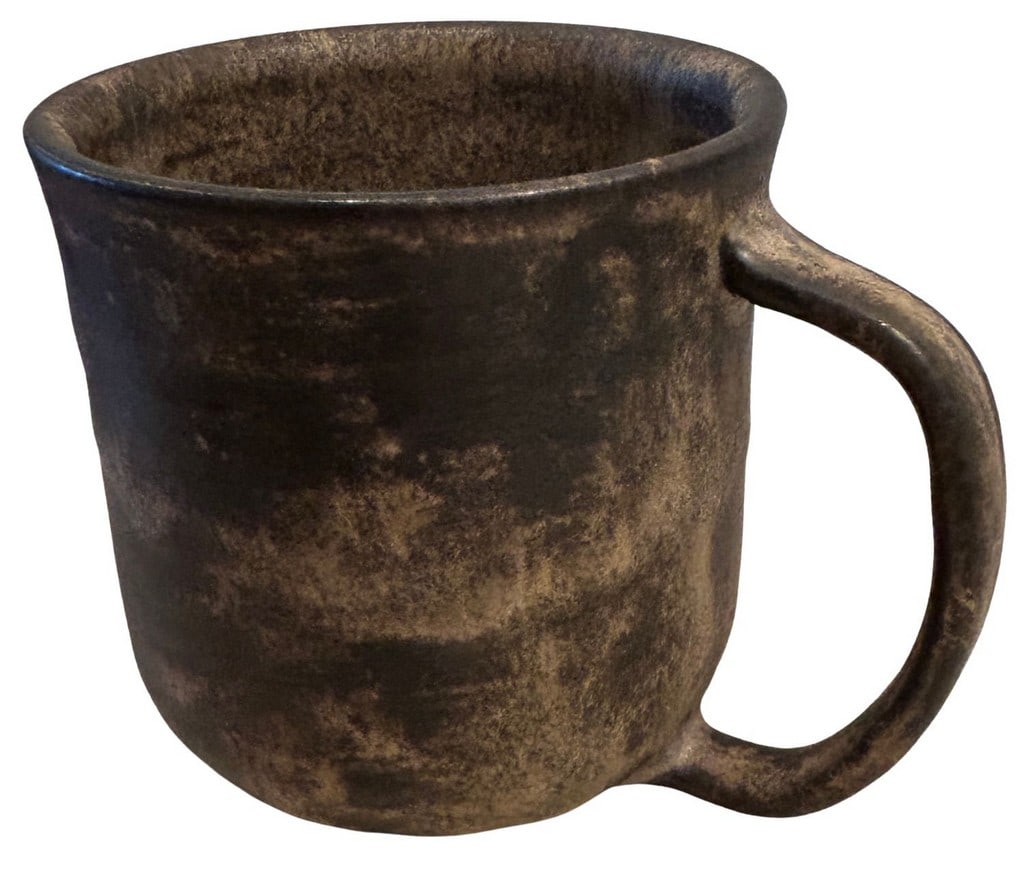 Hand-Thrown Studio Pottery Mug: A rustic, hand-thrown studio pottery mug, likely mid-20th century, featuring a mottled dark brown and tan glazed finish. The mug has a substantial, organic form with a wide mouth and a comfortable loo