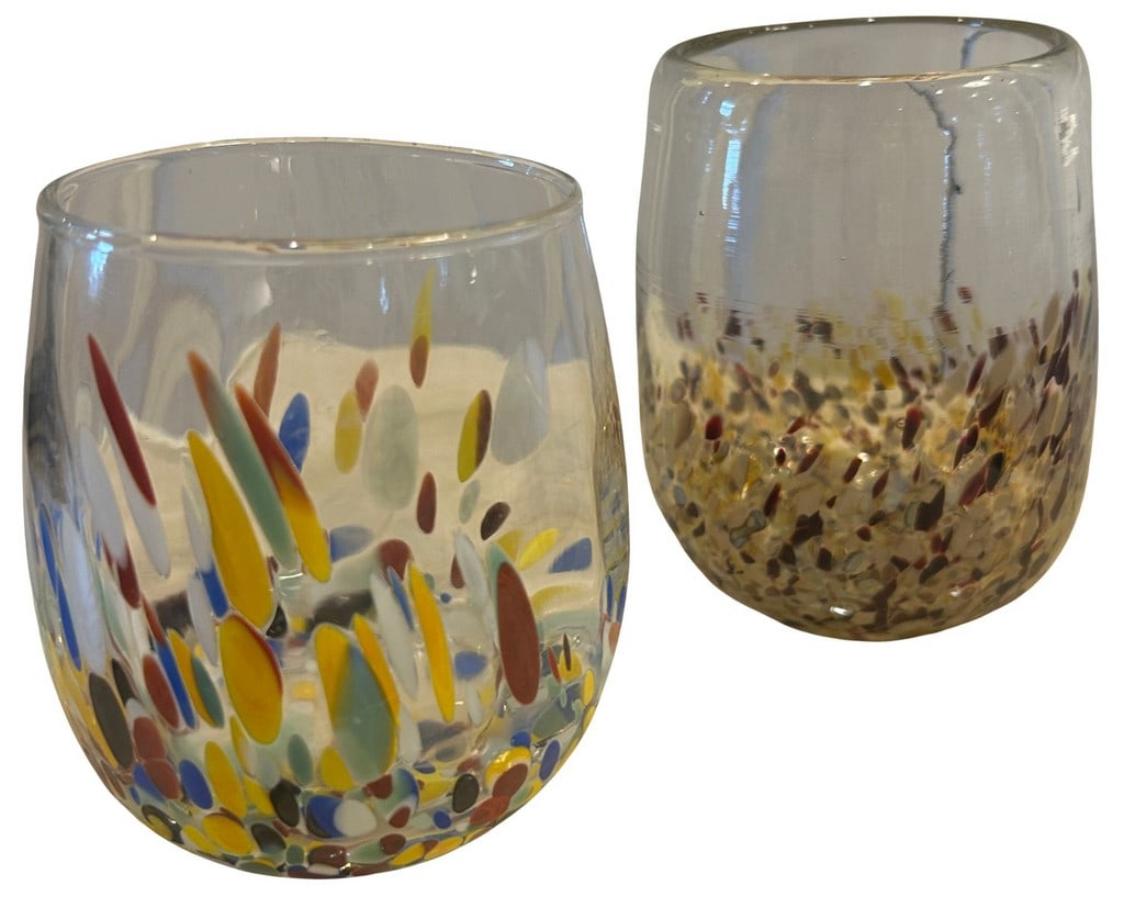 Pair of Art Glass Tumblers: A pair of modern art glass tumblers, featuring clear glass embellished with colorful confetti-like frit in a speckled pattern. One tumbler showcases a vibrant mix of primary and secondary colors