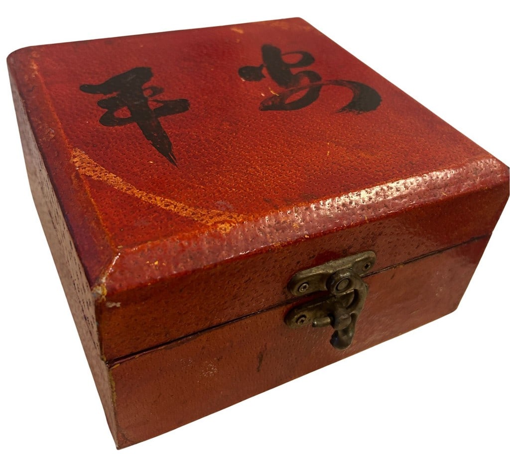 Vintage Asian Lacquered Wooden Box with Calligraphy: This vintage lacquered wooden box features a rustic red finish with significant texture, possibly from deliberate distressing or age. The lid is adorned with black Asian calligraphy. It opens to