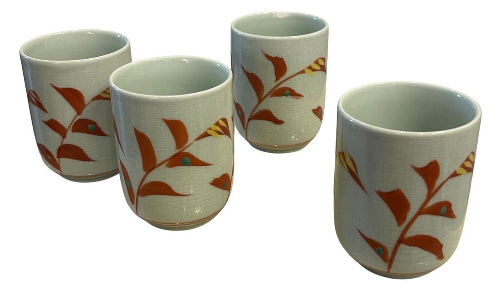 Set of Four Japanese Porcelain Vegetal Theme Tea Cups (Yunomi): A charming set of four Japanese porcelain yunomi (tea cups) featuring a delicate hand-painted design of stylized autumnal foliage in warm terracotta tones, accented with touches of yellow and