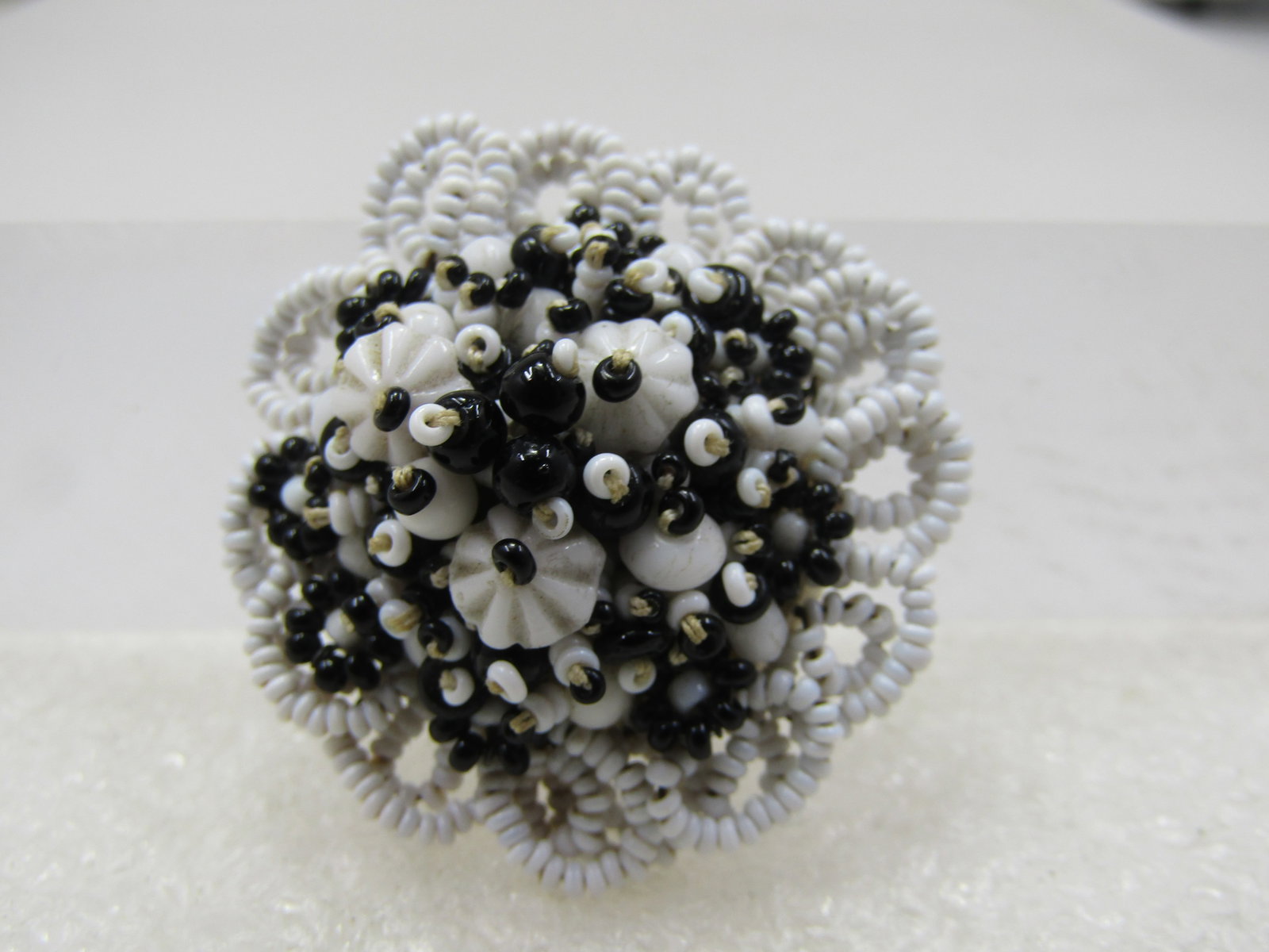 Vintage Black and White Seed Bead Blossom Brooch,1-3/8" Round: Title: Vintage Black and White Seed Bead Blossom Brooch,1-3/8" Round Description: Vintage Black and White Seed Bead Blossom Brooch,1-3/8" Round. This has a looped white beaded edge with a stacked