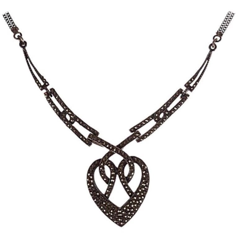 Art Deco Sterling Silver Pave Marcasite Heart Necklace: Title:Art Deco Sterling Silver Pave Marcasite Heart Necklace Description:1940s sterling silver interwoven heart necklace pavé set with marcasites. Bib, 3 3/8”W. Heart pendant, 1”W x 1