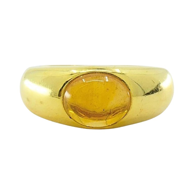 Tiffany & Co. 18K Gold Citrine Cabochon Ring: A timeless statement piece by Tiffany & Co., this ring is crafted in 18 karat yellow gold and showcases a warm citrine cabochon at its center. The stone is bezel-set into a smoothly contoured, polishe