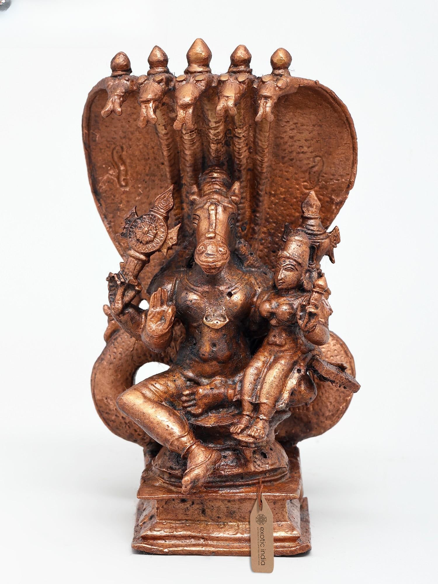 6" Small Lord Hayagriva with Devi Lakshmi | Copper Statue: Embodiment of Divine Knowledge and Prosperity This exquisite copper statue captures the majestic presence of Lord Hayagriva, an avatar of Vishnu, seated in divine union with the goddess Lakshmi. Lord