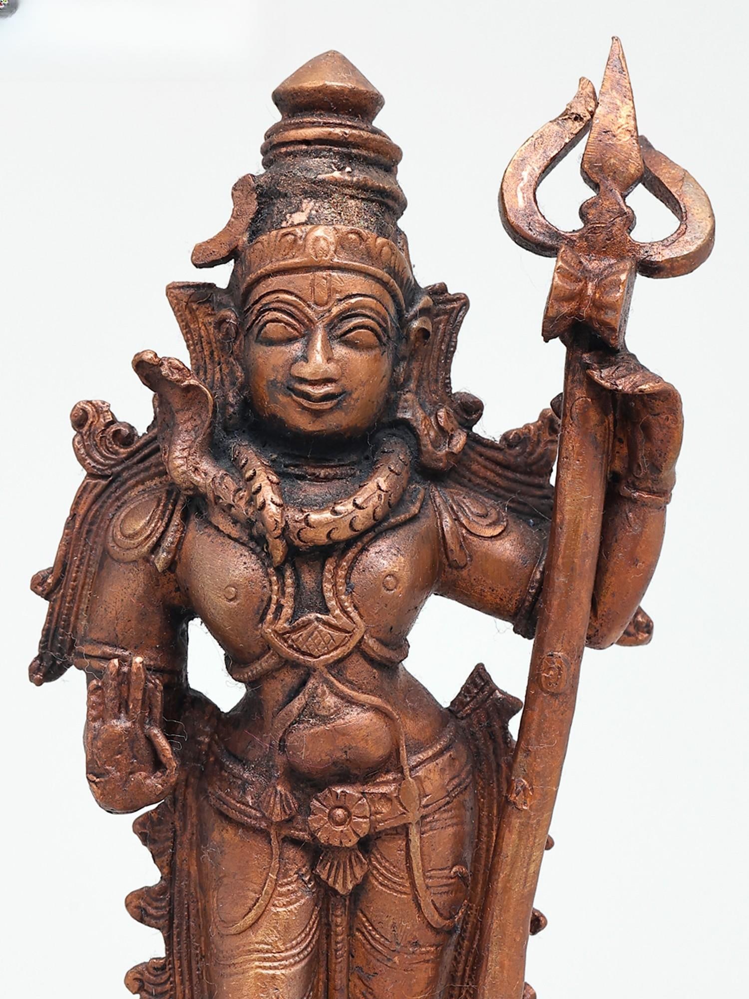 7" Standing Lord Shiva with Trident in Blessing Gesture | Copper Statue: The Auspicious Form of Lord Shiva This exquisite copper statue captures the divine essence of Lord Shiva, one of the principal deities of Hinduism. Standing in a graceful posture, the divine form