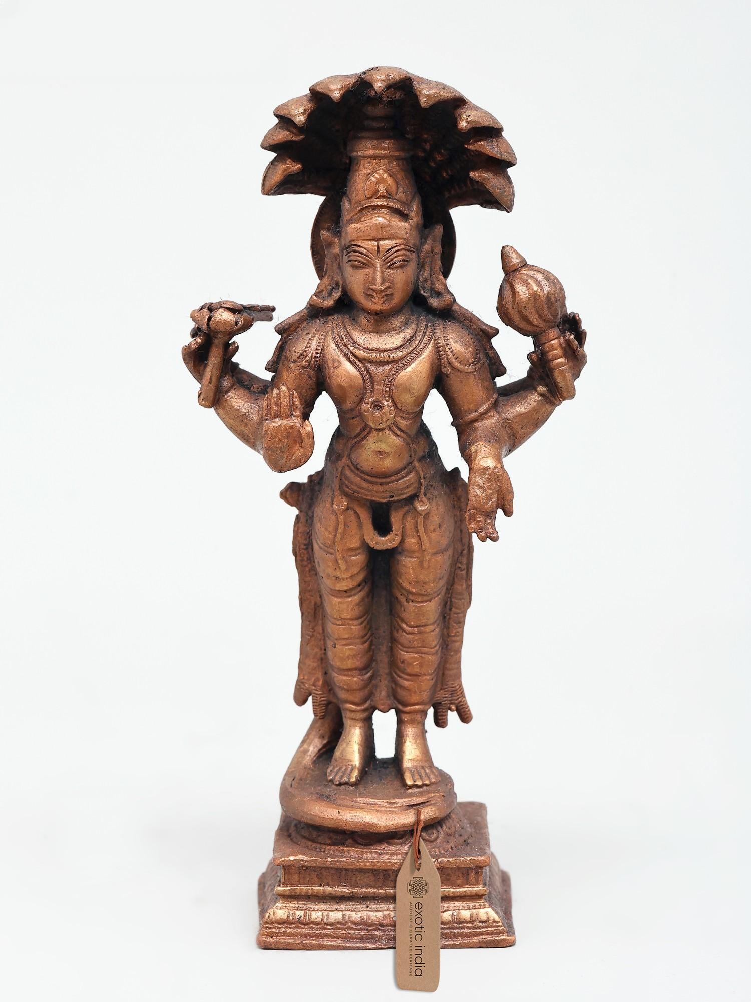 6" Small Four Armed Standing Lord Vishnu | Copper Statue: The Preserver in Form This exquisite copper statue captures the benevolent presence of Lord Vishnu, the preserver and protector of the universe in Hindu mythology. Rendered in a striking four-armed po