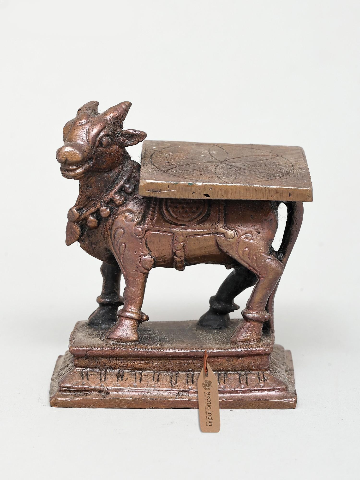 3" Small Nandi Idol Peeta | Copper Statue: Embrace Divine Serenity with the Nandi Peeta Idol Invoking a sense of peace and devotion, this exquisite copper Nandi idol, complete with its peeta (base), is a testament to skilled craftsmanship and