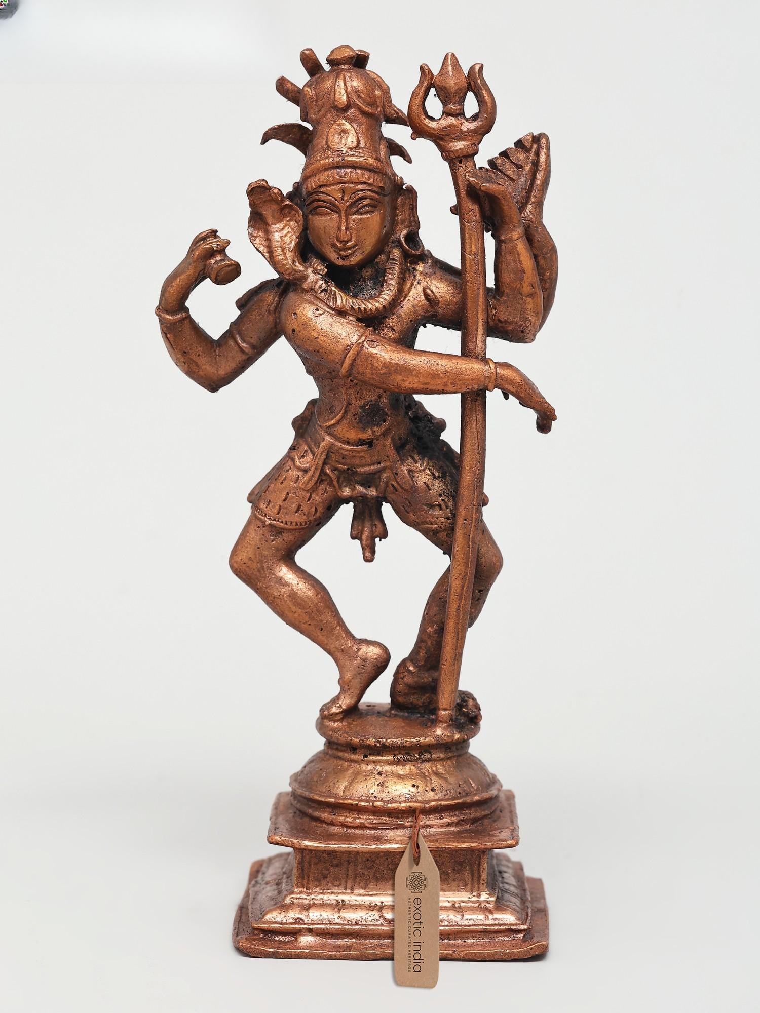 6" Four Armed Dancing Lord Shiva | Copper Statue: The Cosmic Dance of Creation and Destruction Behold the divine form of Lord Shiva, the primordial dancer, captured in this exquisite copper statue. With four arms outstretched in a dynamic pose, this