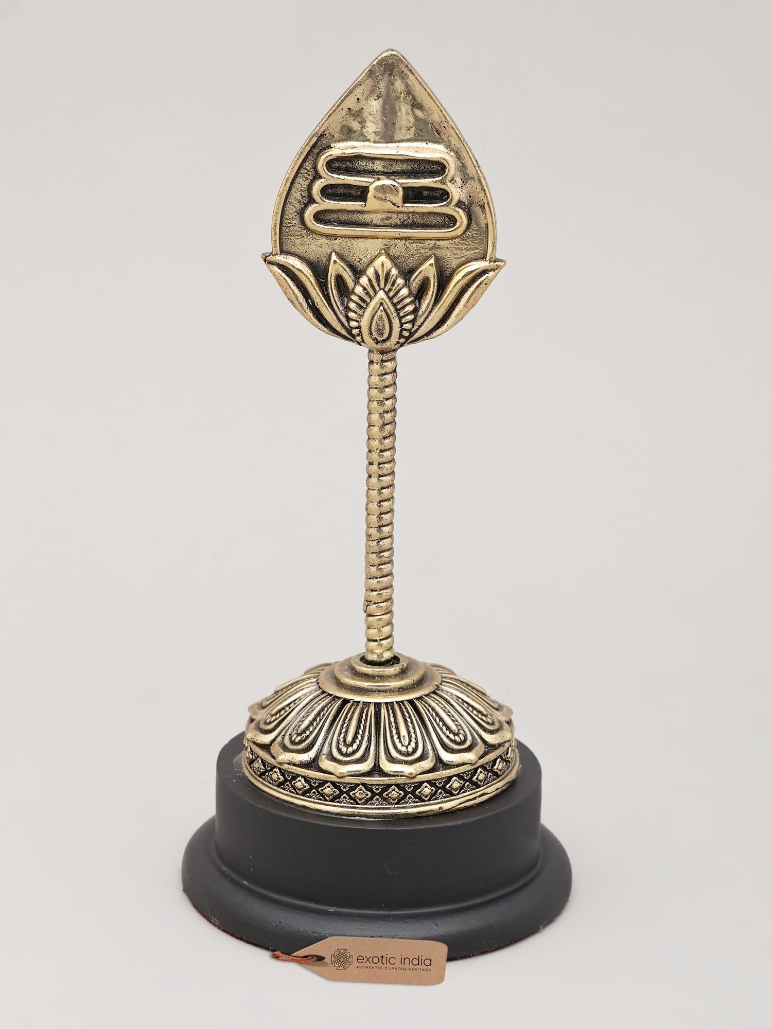 Superfine Vel of Murugan with Wood Base | Brass Statue | Made in India: The Mighty Vel of Murugan: A Symbol of Victory and Divine Power This exquisite brass representation of the Vel, the divine spear wielded by Lord Murugan, is a potent symbol of spiritual strength and