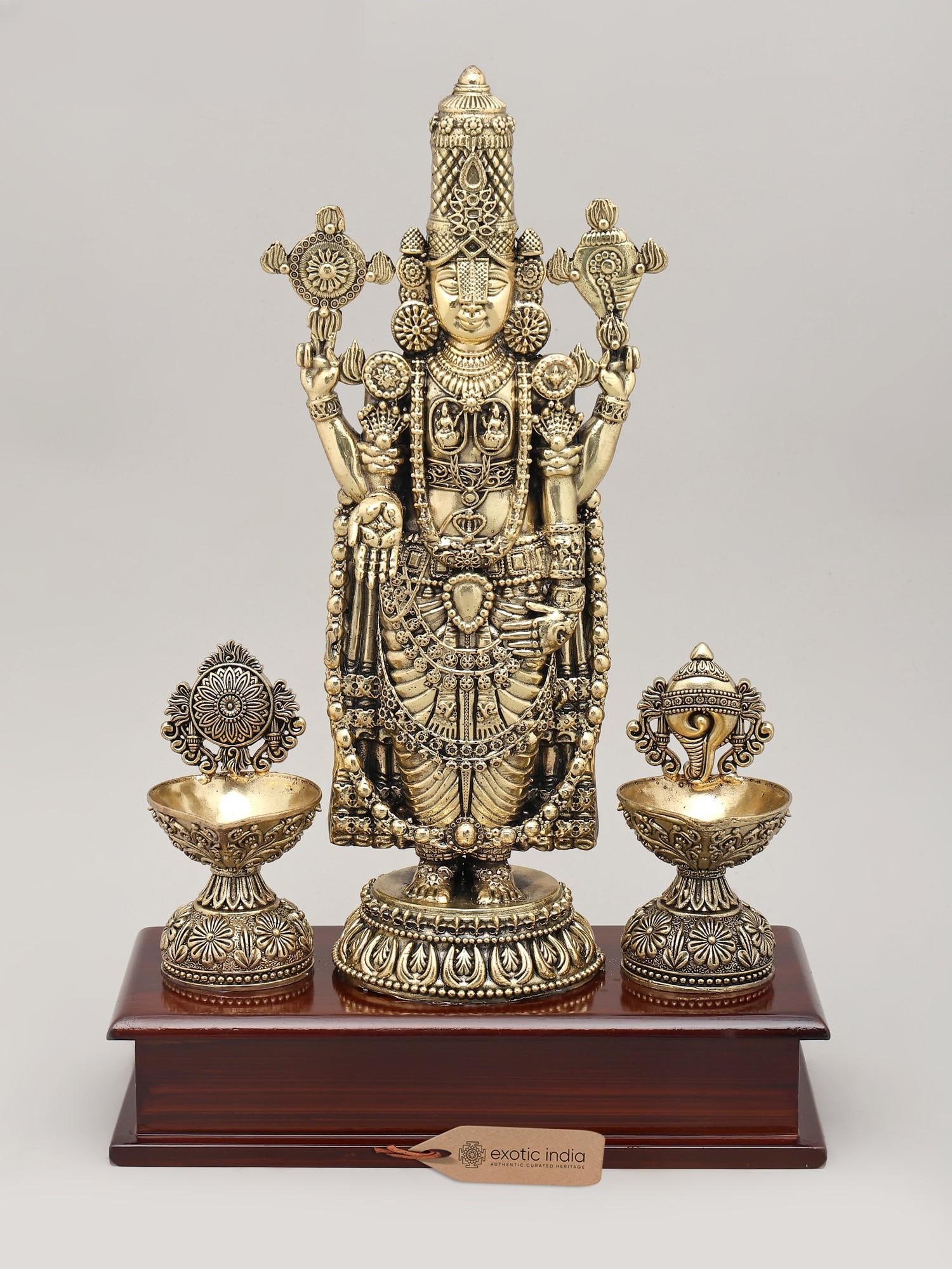 13" Superfine Lord Venkateswara Idol with Vaishnava Symbols Oil Lamp and Wood Base | Brass Sculpture: A Divine Presence for Your Sacred Space Invoke the blessings of Lord Venkateswara, the presiding deity of the sacred hills of Tirumala, with this exquisite brass idol. Crafted with exceptional superfi