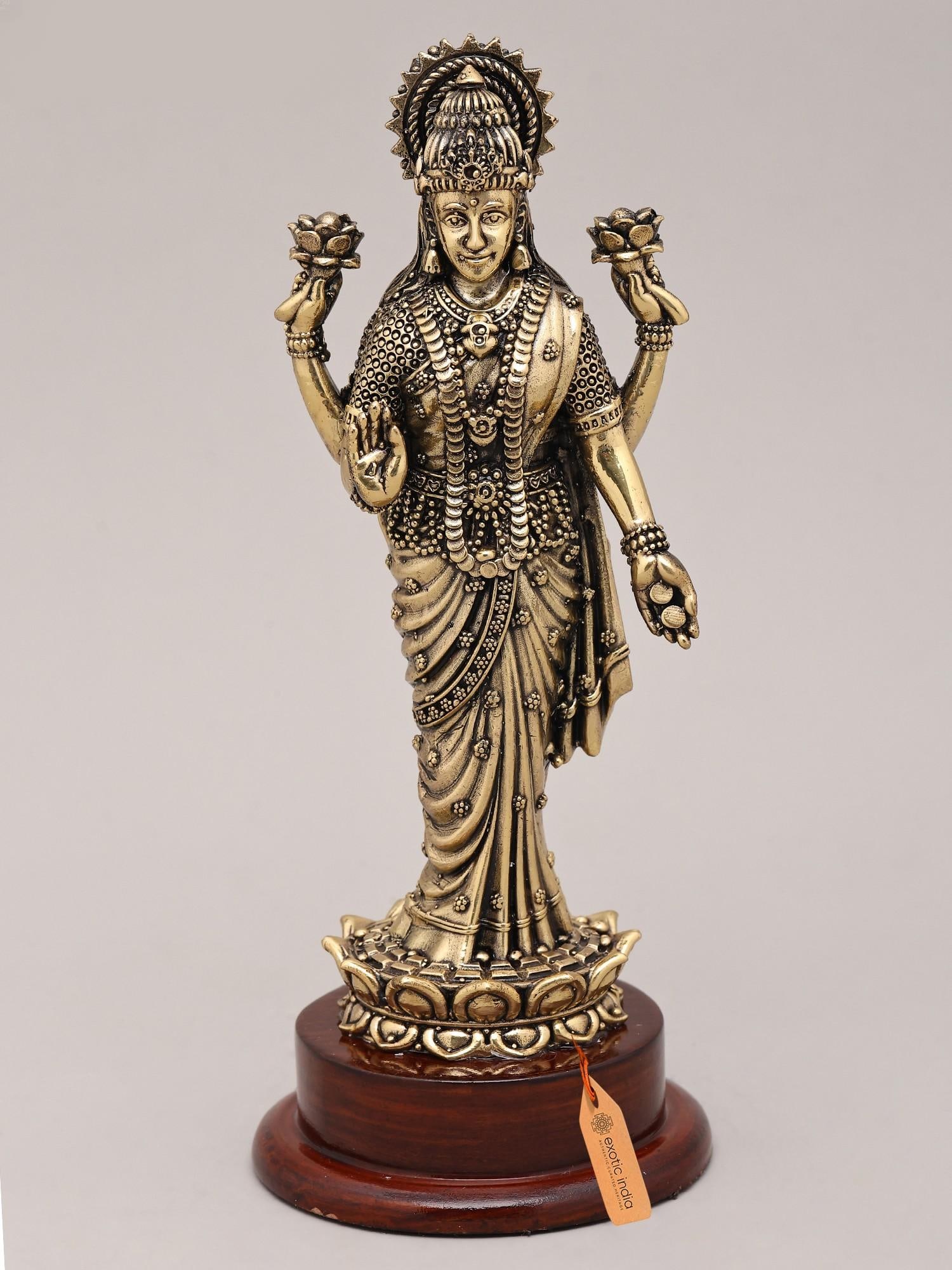 7" Superfine Goddess Lakshmi Standing on Lotus with Wood Base | Brass Sculpture: Embodiment of Prosperity and Grace: Goddess Lakshmi Sculpture This exquisite brass sculpture captures the divine essence of Goddess Lakshmi, the revered Hindu deity of wealth, prosperity, and