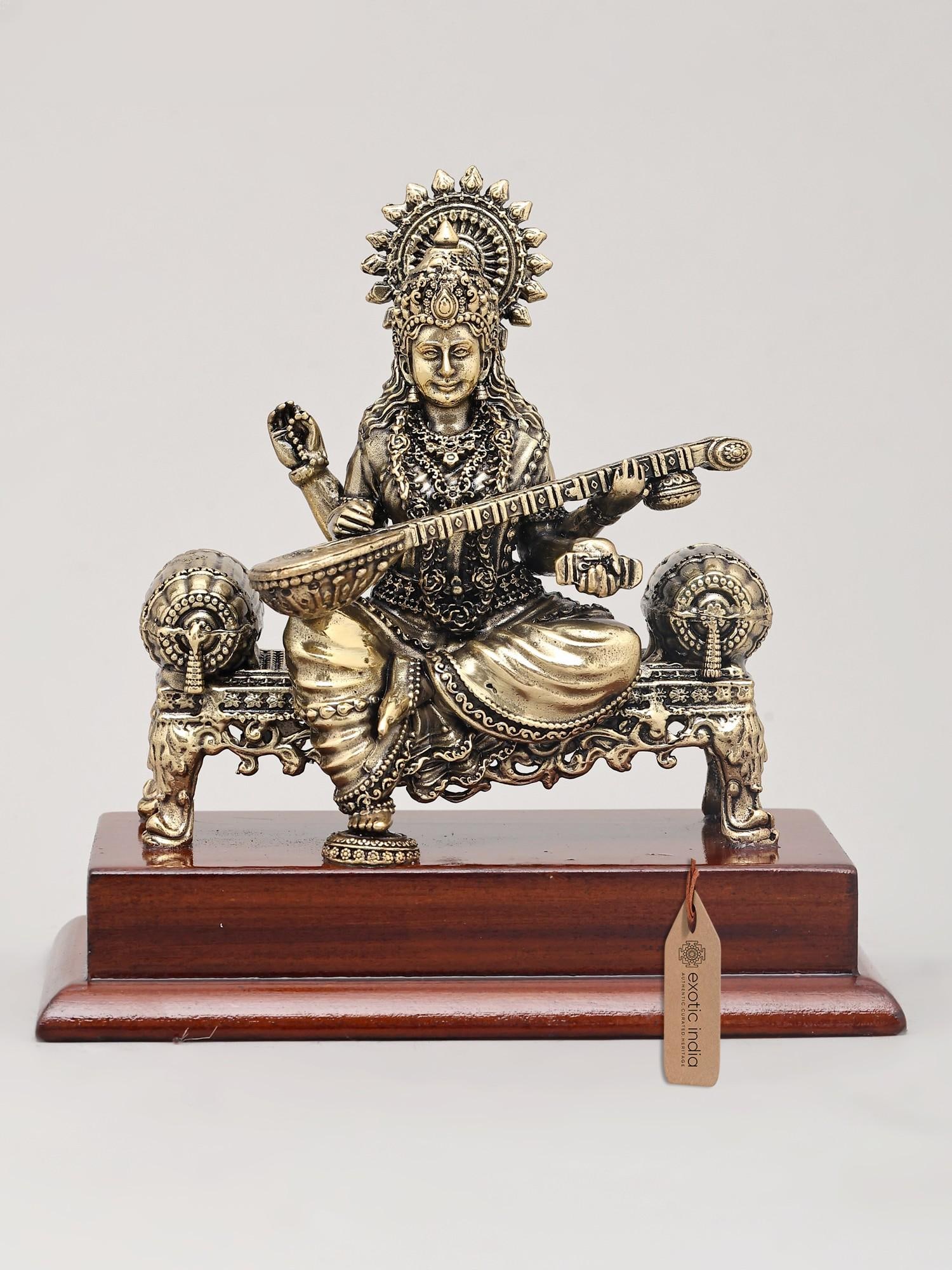 5" Small Superfine Goddess Saraswati - The Deity of Knowledge, Music, Art, and Learning with Wood: Embrace the Divine Muse This exquisite brass idol captures the serene and benevolent presence of Goddess Saraswati, the revered deity of knowledge, music, art, and learning in Hindu tradition. Seated 