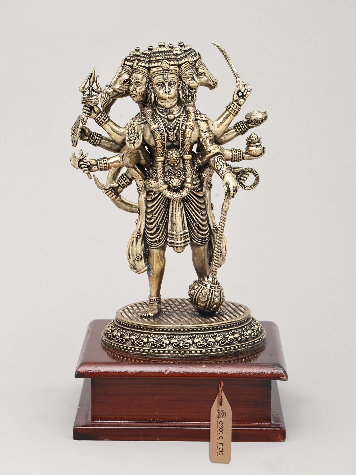 Superfine Ten Armed Panchamukhi Hanuman in Standing Gesture with Wood Base | Brass Sculpture: Embodiment of Divine Might: The Panchamukhi Hanuman This exquisite brass sculpture captures the awe-inspiring form of Panchamukhi Hanuman, the five-faced manifestation of the devoted son of Vayu. In