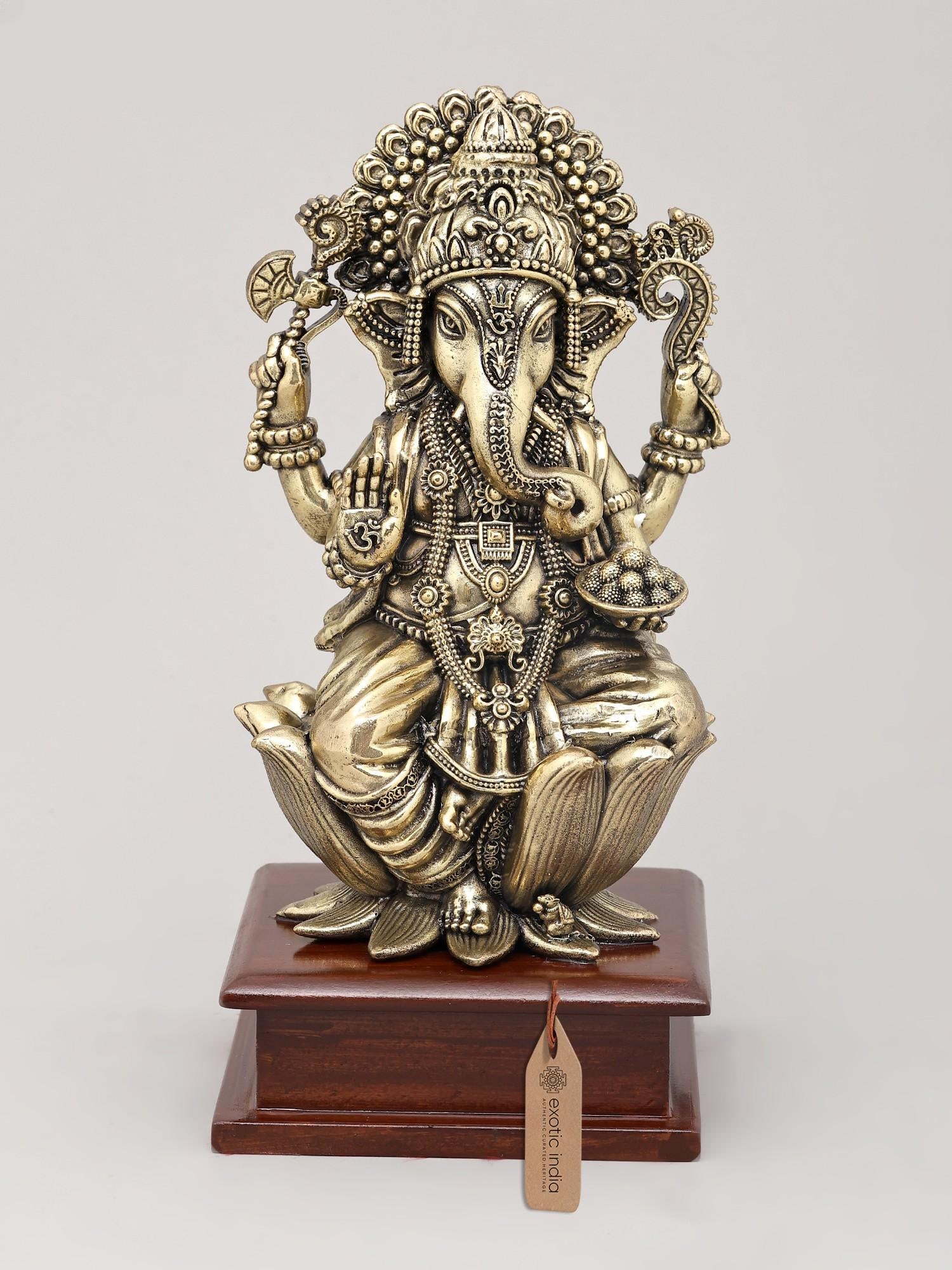 9" Superfine Lord Ganesha in Blessing Posture Seated on Wood Base | Brass Idol: The Auspicious Presence of Ganesha: Remover of Obstacles This exquisite brass sculpture captures the benevolent form of Lord Ganesha, the beloved elephant-headed deity revered as the remover of obstac