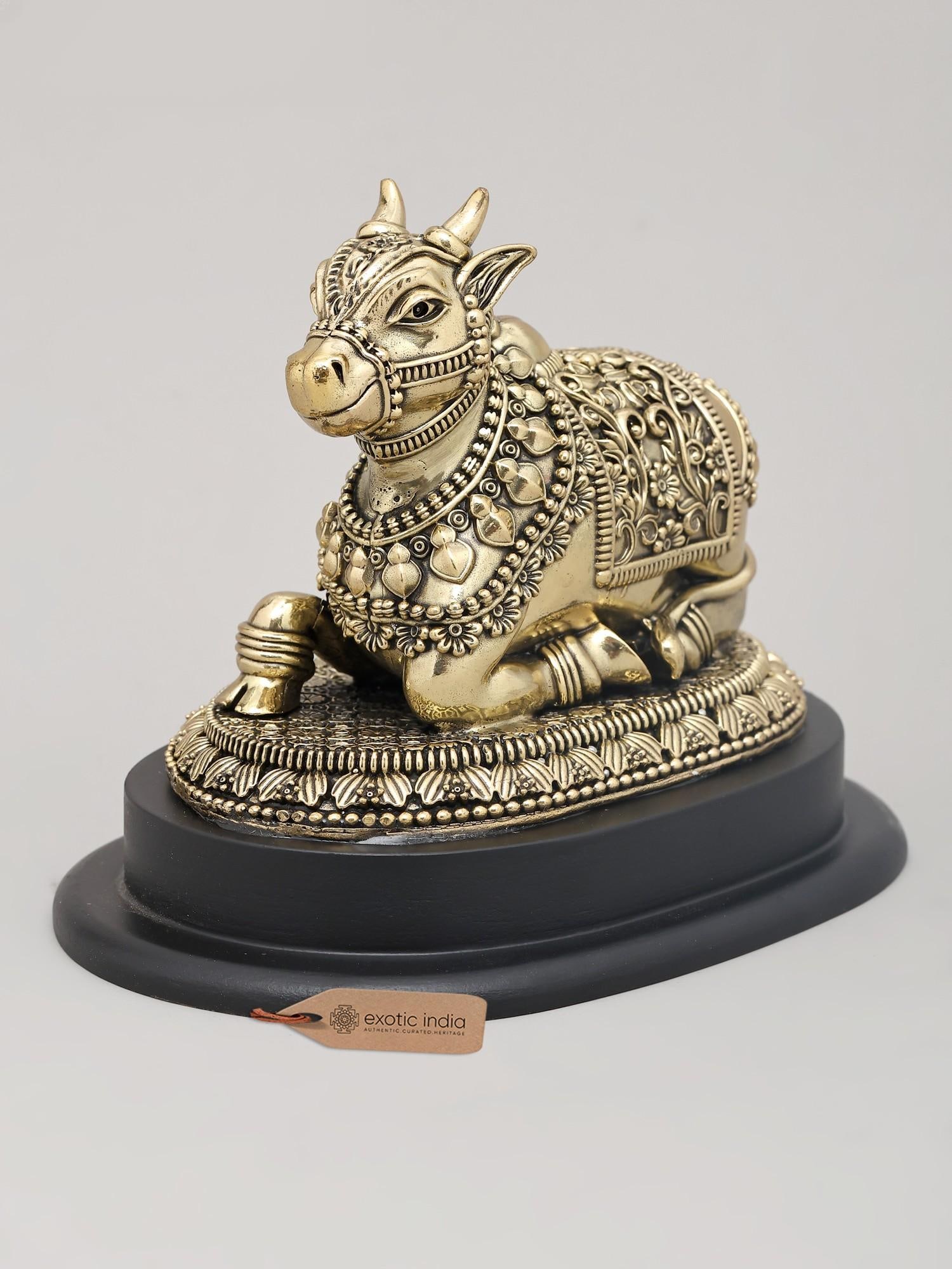6" Superfine Seated Nandi Idol - The Vahana of Shiva with Intricate Carving and Wood Base | Brass: The Steadfast Guardian: A Brass Nandi Idol This exquisite brass Nandi idol embodies devotion, strength, and the divine connection to Lord Shiva. Crafted with remarkable superfine detailing, this repre