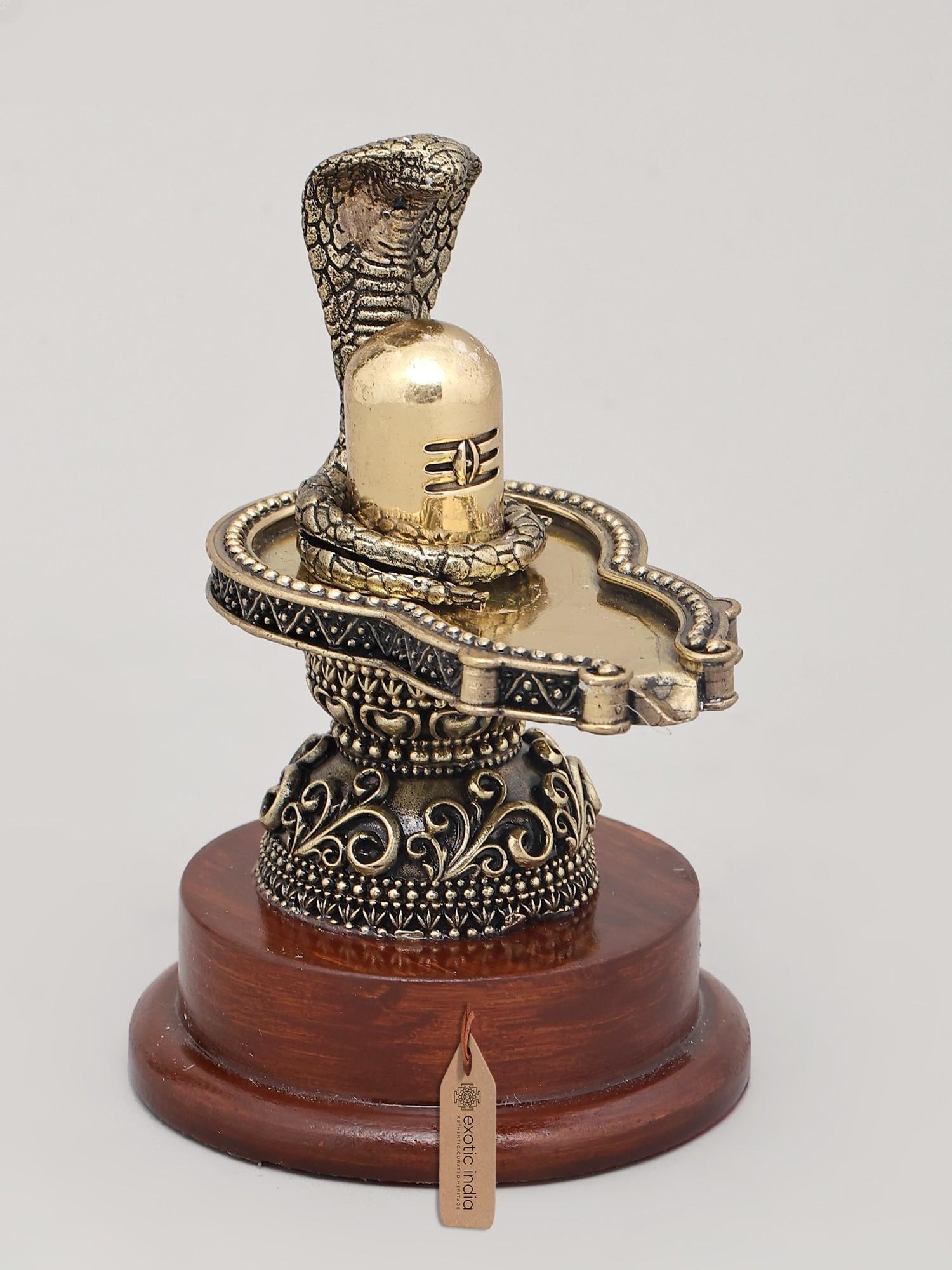 5" Small Superfine Idol of Shiva Lingam with Wood Base and Vasuki Serpent | Brass Statue: A Divine Representation of Cosmic Energy This exquisitely crafted brass statue embodies the profound symbolism of Lord Shiva, the destroyer and transformer in the Hindu pantheon. The Shiva Lingam, a f