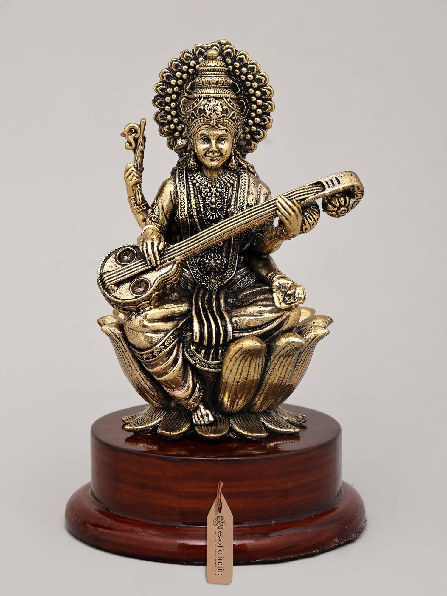 5" Small Superfine Idol of Goddess Saraswati Playing Sitar on Wood Base | Brass Statue: Embodiment of Wisdom and Artistry This exquisite brass idol captures the divine essence of Goddess Saraswati, the Hindu deity of knowledge, music, art, wisdom, and learning. Depicted in a serene