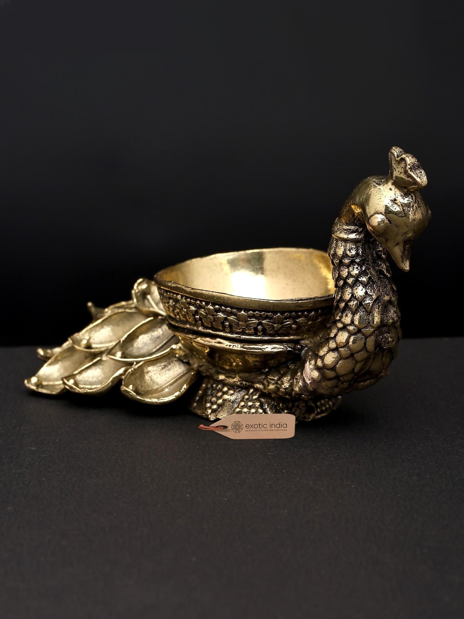4" Superfine Peacock Oil Lamp with Single Wick in Brass | Made in India: The Majestic Peacock: A Symbol of Divinity and Light The peacock, with its resplendent plumage and graceful bearing, has long been revered in Indian culture and mythology. It is a creature of exquisit