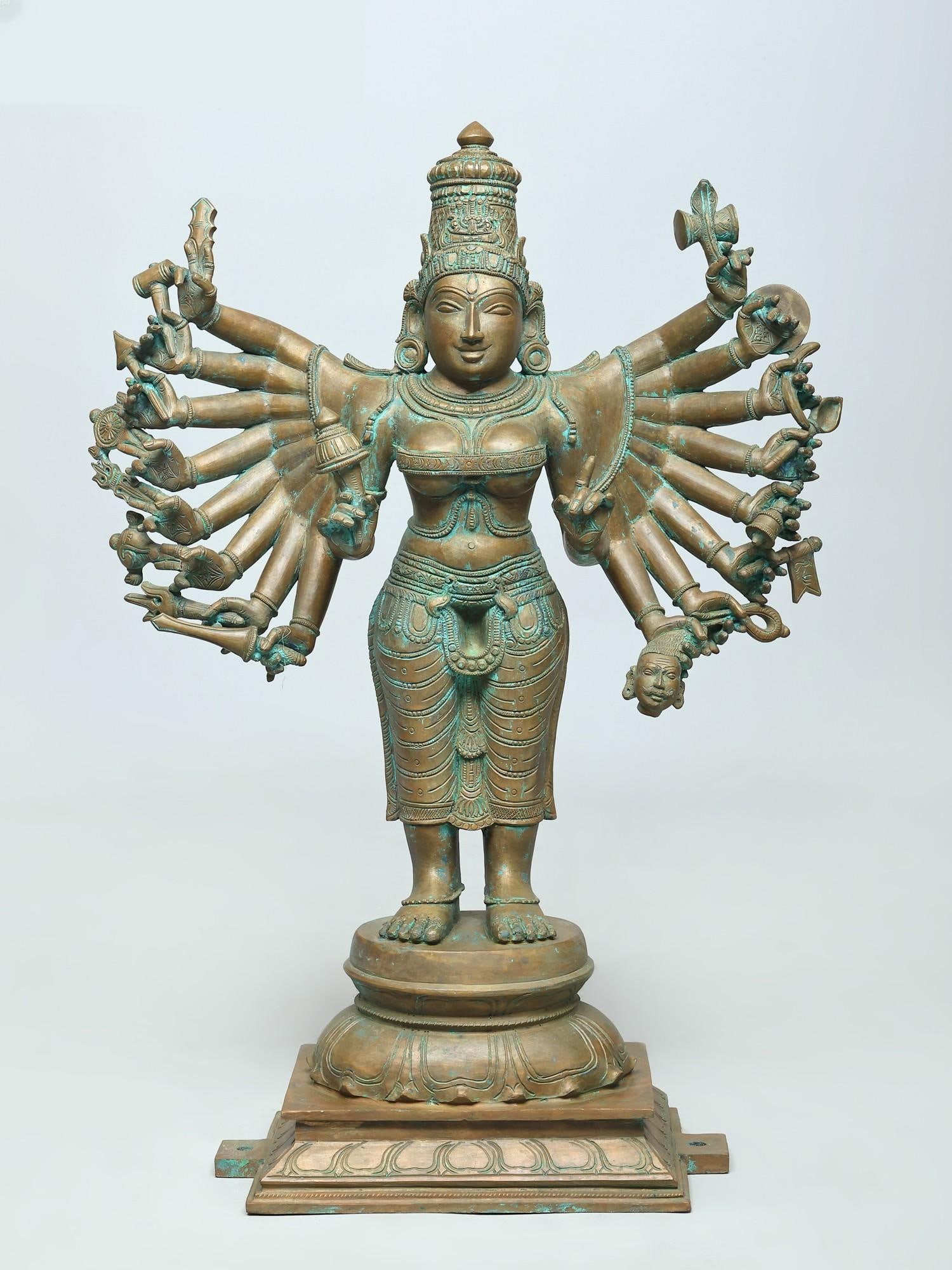 25" Eighteen Armed Goddess Durga Standing on Lotus Pedestal | Bronze Statue: The Divine Embodiment of Strength and Protection Behold a magnificent bronze depiction of Goddess Durga, the ultimate protector and vanquisher of evil. This striking statue captures the divine mother 