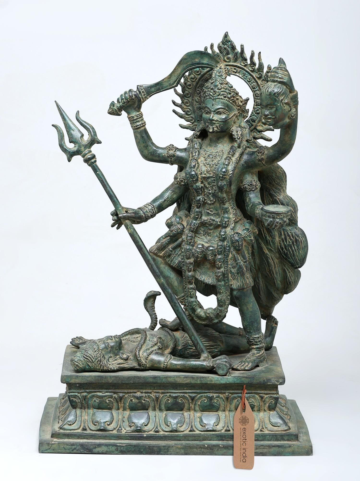16" Goddess Kali Standing on Lord Shiva | Brass Statue: Embodiment of Divine Ferocity and Transformation This striking brass statue captures the awe-inspiring form of Goddess Kali, a powerful deity in Hinduism known for her fierce aspect and her role in de