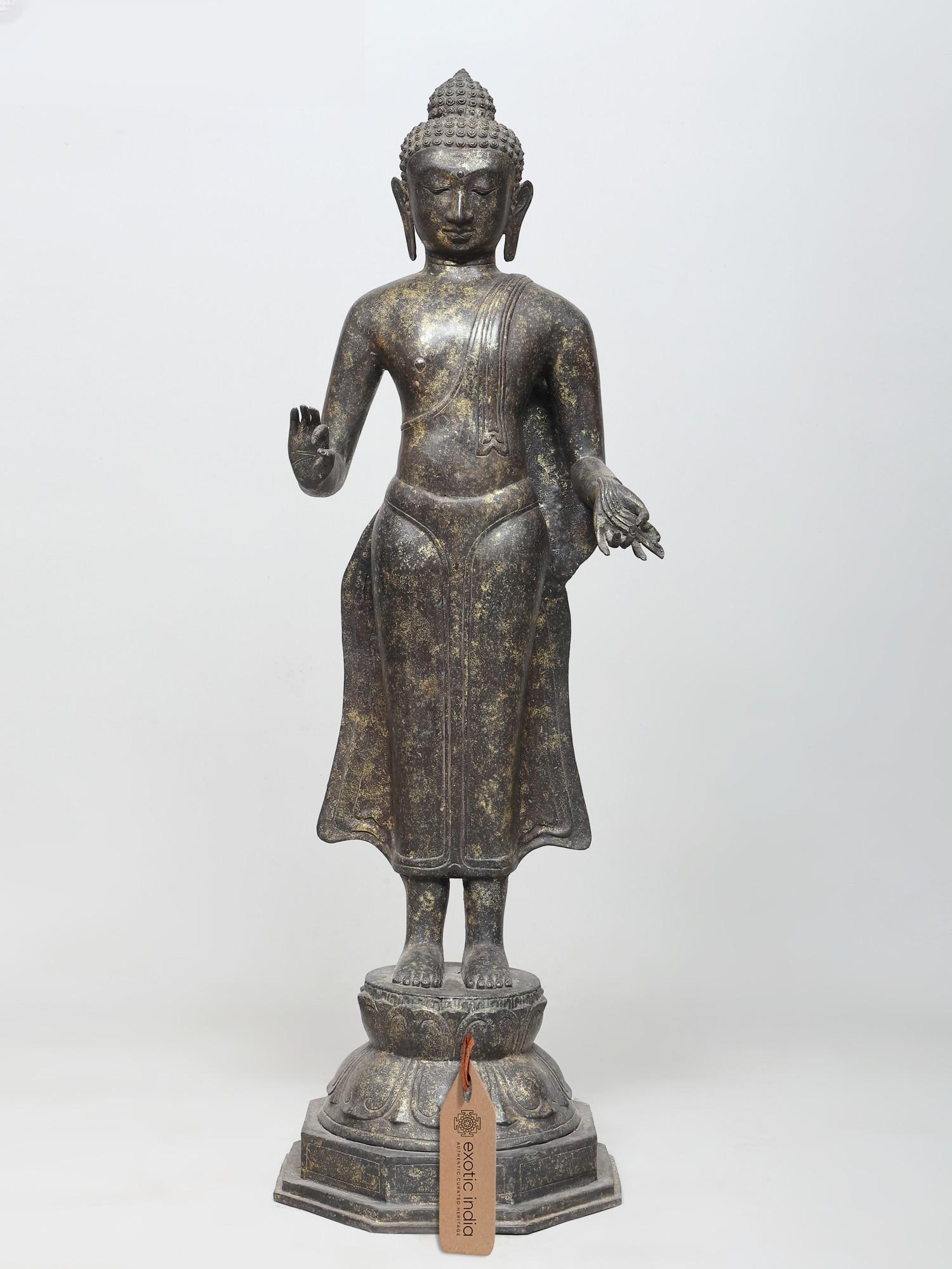 38" Large Standing Lord Buddha in Vitark Mudra | Brass Statue: A Symbol of Enlightenment and Guidance This magnificent brass statue captures the serene presence of Lord Buddha in the Vitark Mudra, a gesture of teaching, discussion, and the transmission of wisdom.