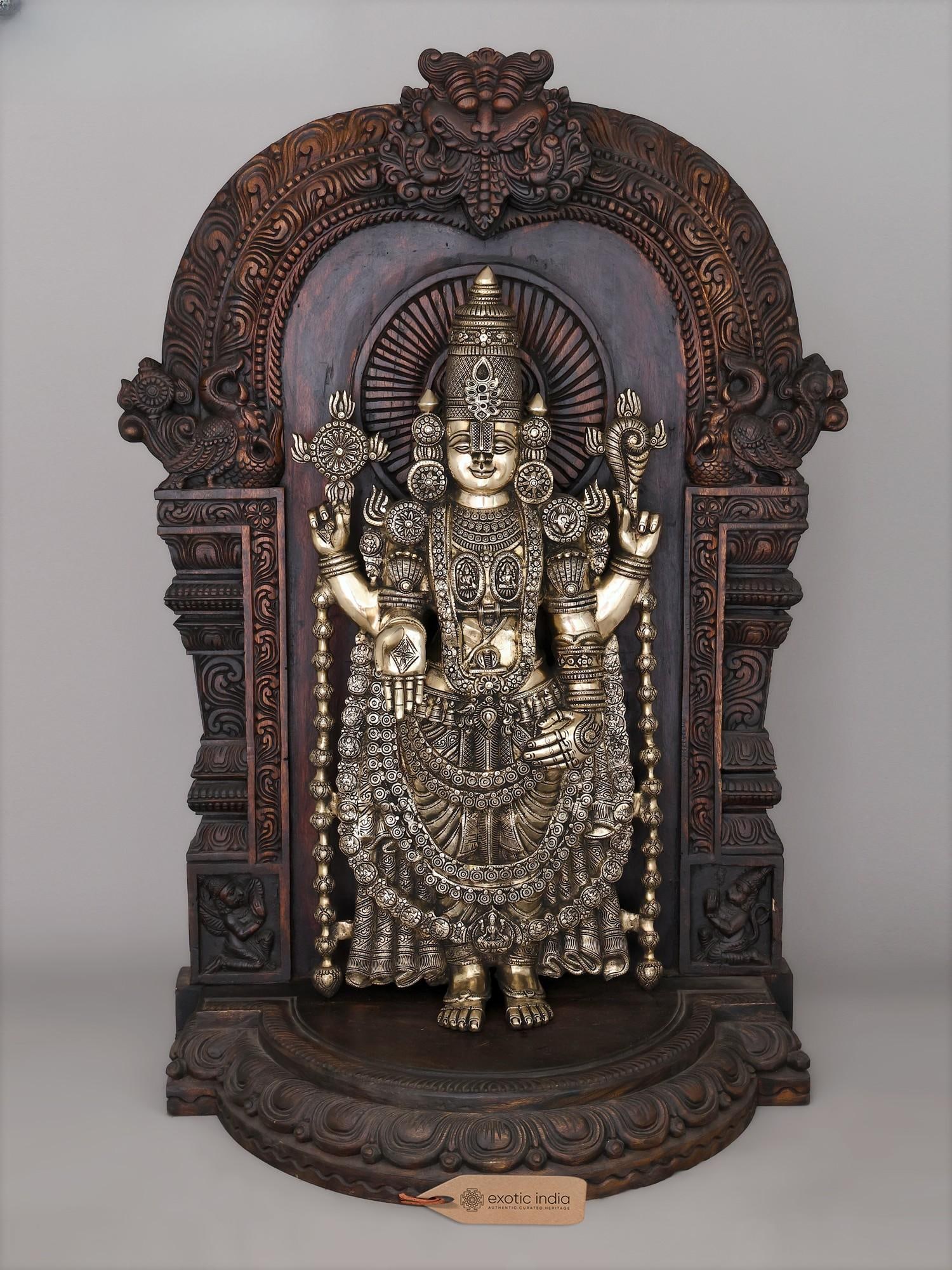 48" Large Superfine Brass Lord Tirupati Balaji (Venkateswara) with Wood Carved Kirtimukha Throne |: The Divine Presence of Lord Venkateswara This magnificent brass rendition of Lord Tirupati Balaji, also known as Venkateswara, embodies the divine grace and auspicious presence of one of Hinduism's mo