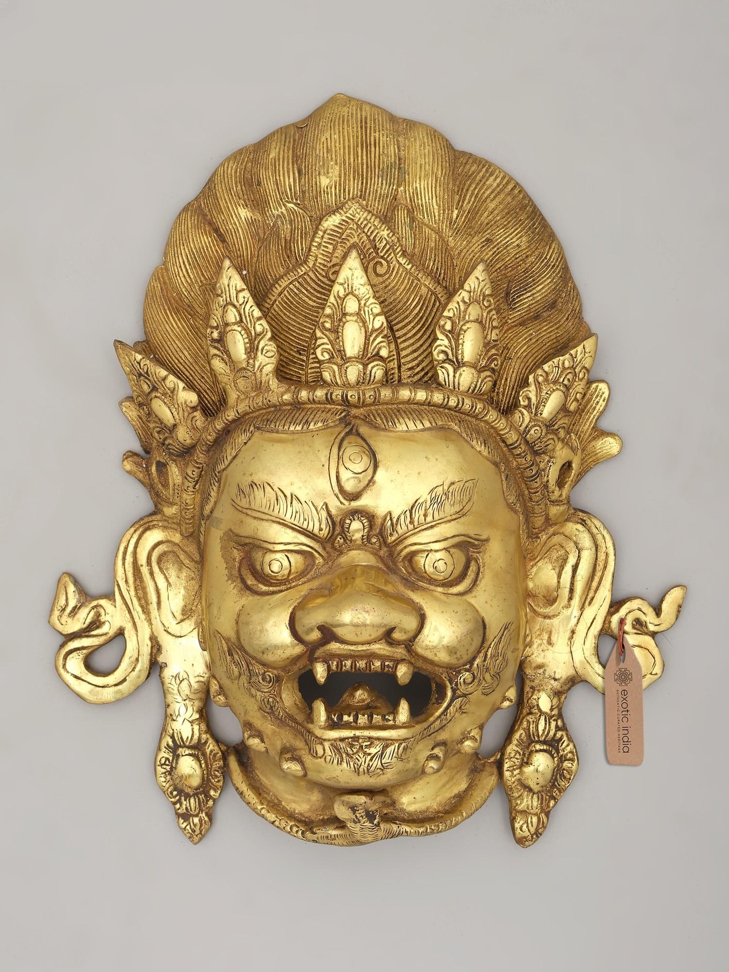 13" Kaal Bhairava Head for Wall | Brass Statue | Made in India: A Visage of Divine Power This striking brass head, representing Kaal Bhairava, is more than just an object of art; it is a powerful symbol steeped in rich mythology and spiritual significance. Kaal Bh