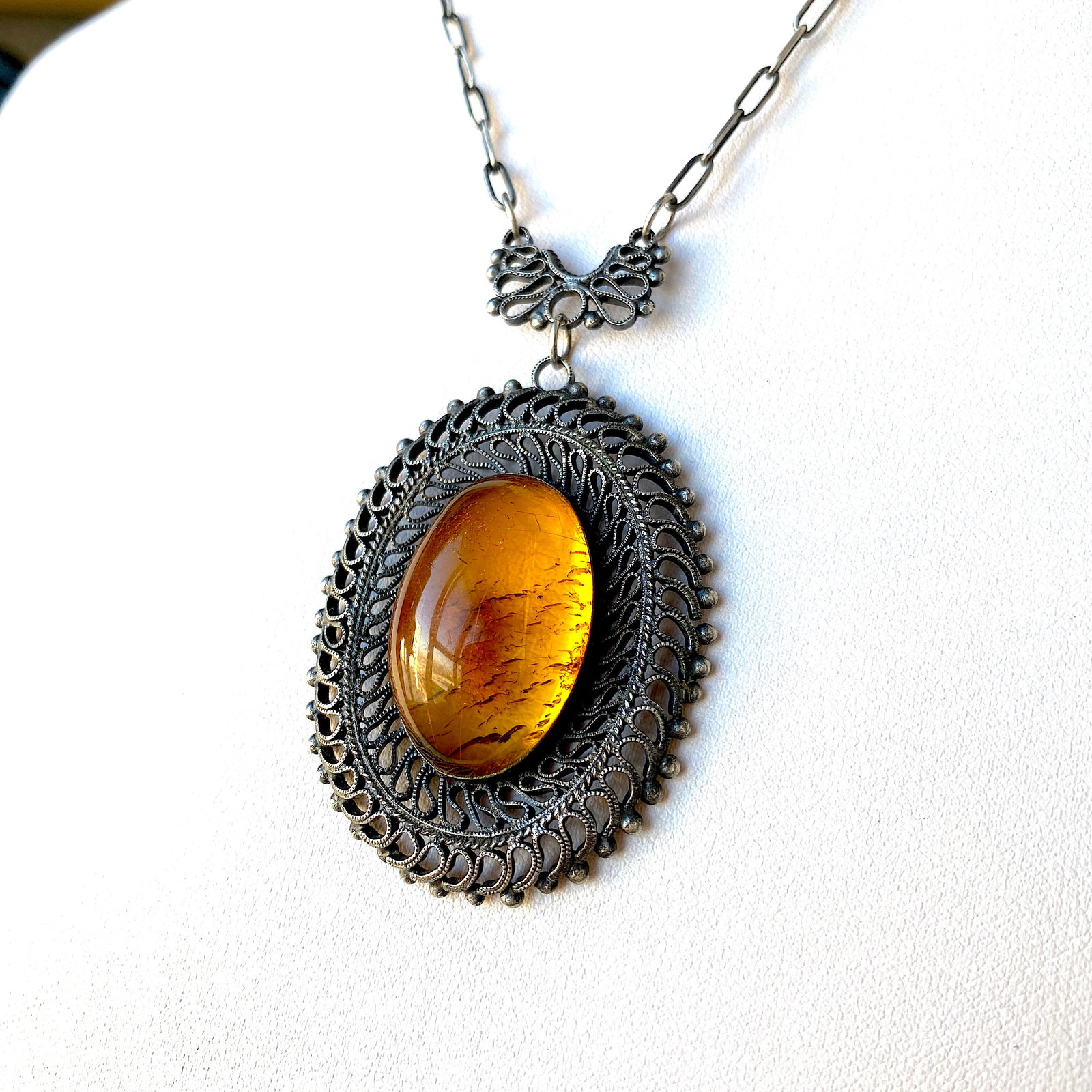 Extraordinary Unique Vintage Amber Pendant shaped like an Ornament: Title:Extraordinary Unique Vintage Amber Pendant shaped like an Ornament Metal:Metal Gemstone:Amber Weight:17.8 g Size:Size: 600.0 x 60.0 x 12.0 mm Size: 23.622 x 2.362 x 0.472 inches Made